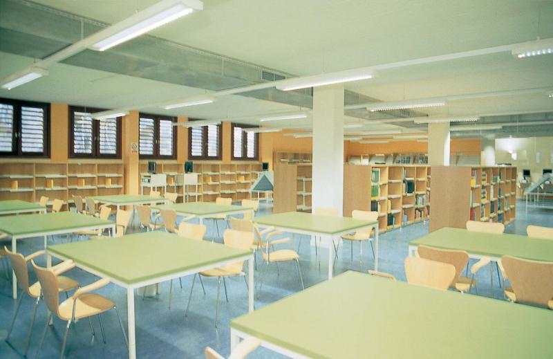 Sala de lectura de planta diáfana con puestos de trabajo.