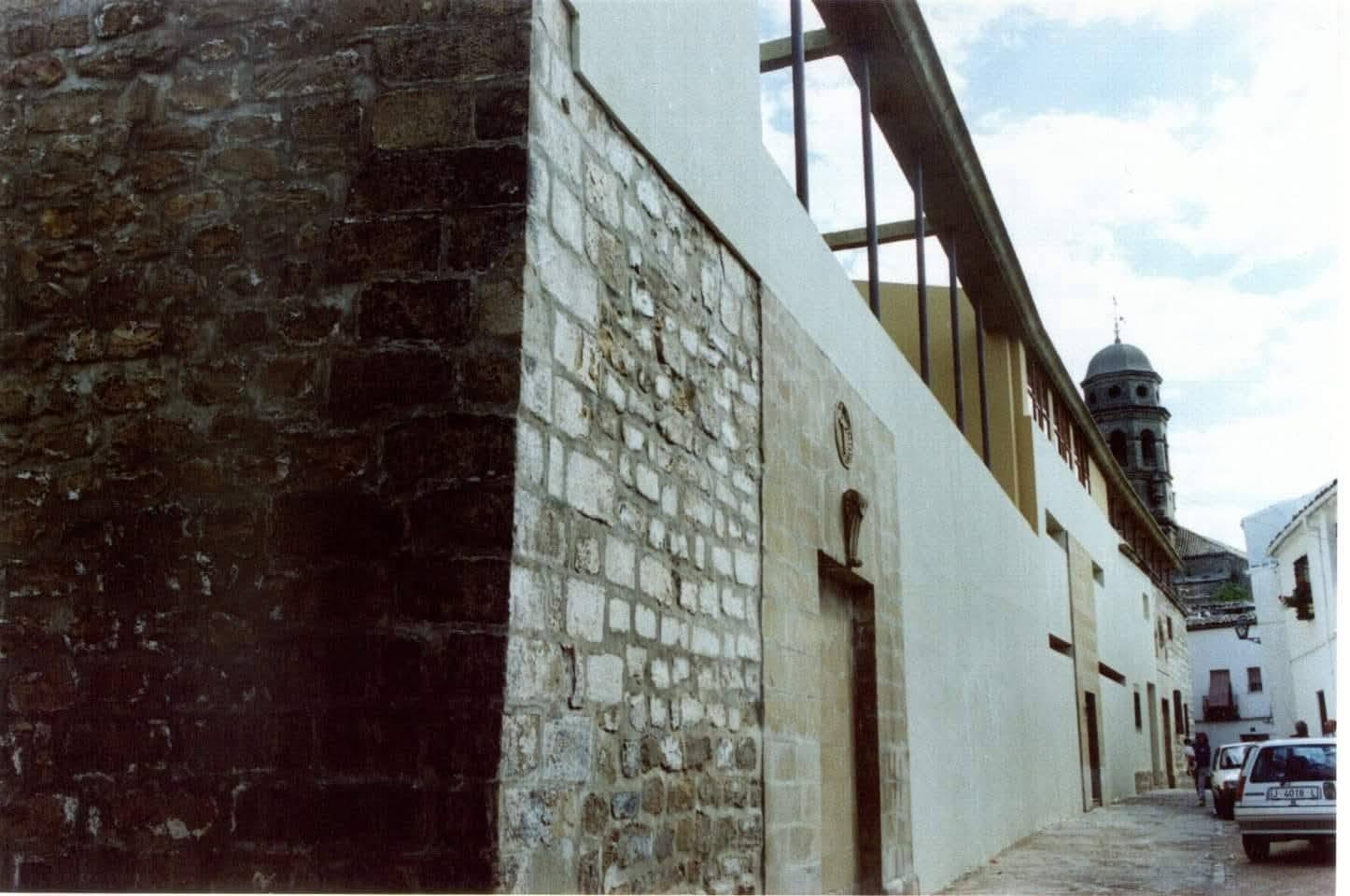 La misma fachada tras la rehabilitación: sillería restaurada, revocos claros y remate contemporáneo con pérgola metálica.