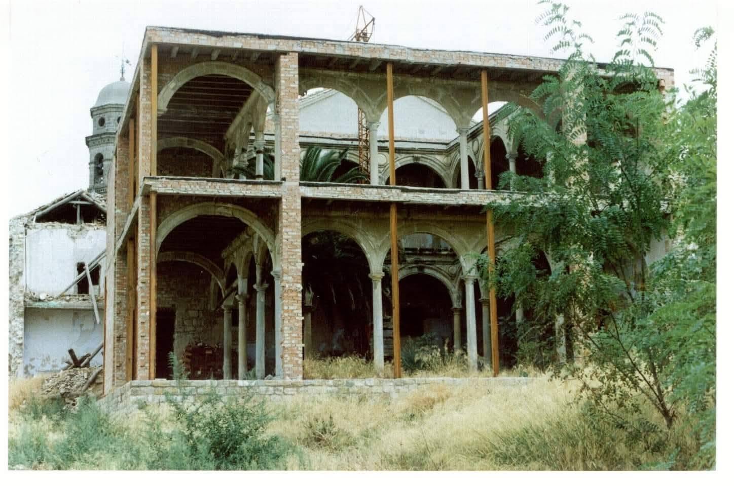 Estado de ruina del convento antes de la intervención: estructura interior descubierta con arcadas y contrafuertes visibles entre la vegetación.